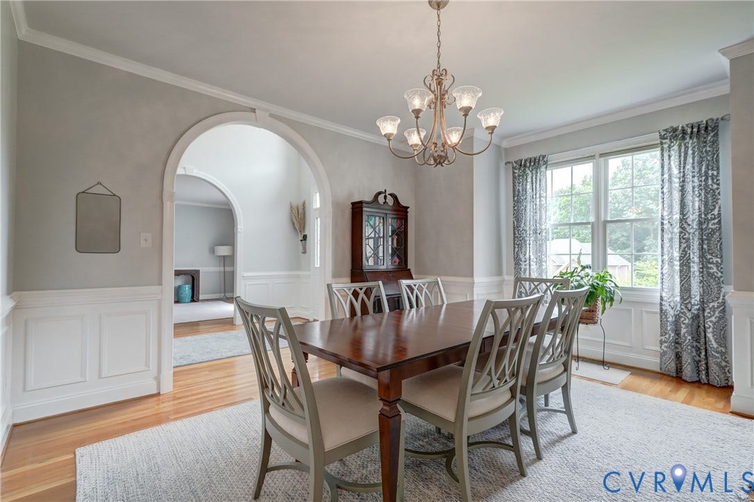 332 Rexmoor Terrace, Richmond, VA 23236 Dining room featuring a multi-bulb chandelier, hardwood flooring, wainscoting, and large windows