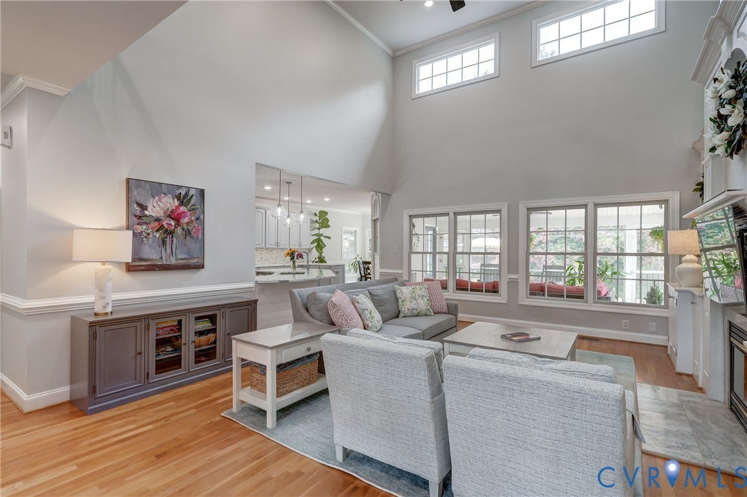 332 Rexmoor Terrace, Richmond, VA 23236 Expansive living room featuring vaulted ceilings, wood-finish flooring, a fireplace with a detailed mantel, and multiple large windows