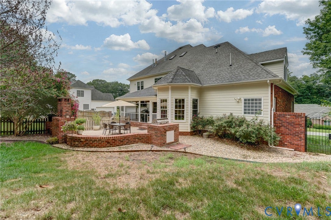 332 Rexmoor Terrace, Richmond, VA 23236 Expansive backyard featuring a multi-level brick patio, a built-in outdoor fireplace, and a screened-in porch with multiple windows