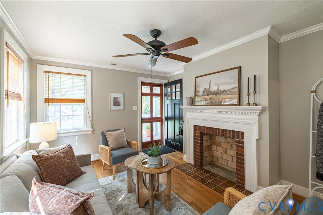3903 Floyd Avenue, Richmond, VA 23221 Living area featuring a classic brick fireplace with a white mantel, hardwood flooring, and crown molding