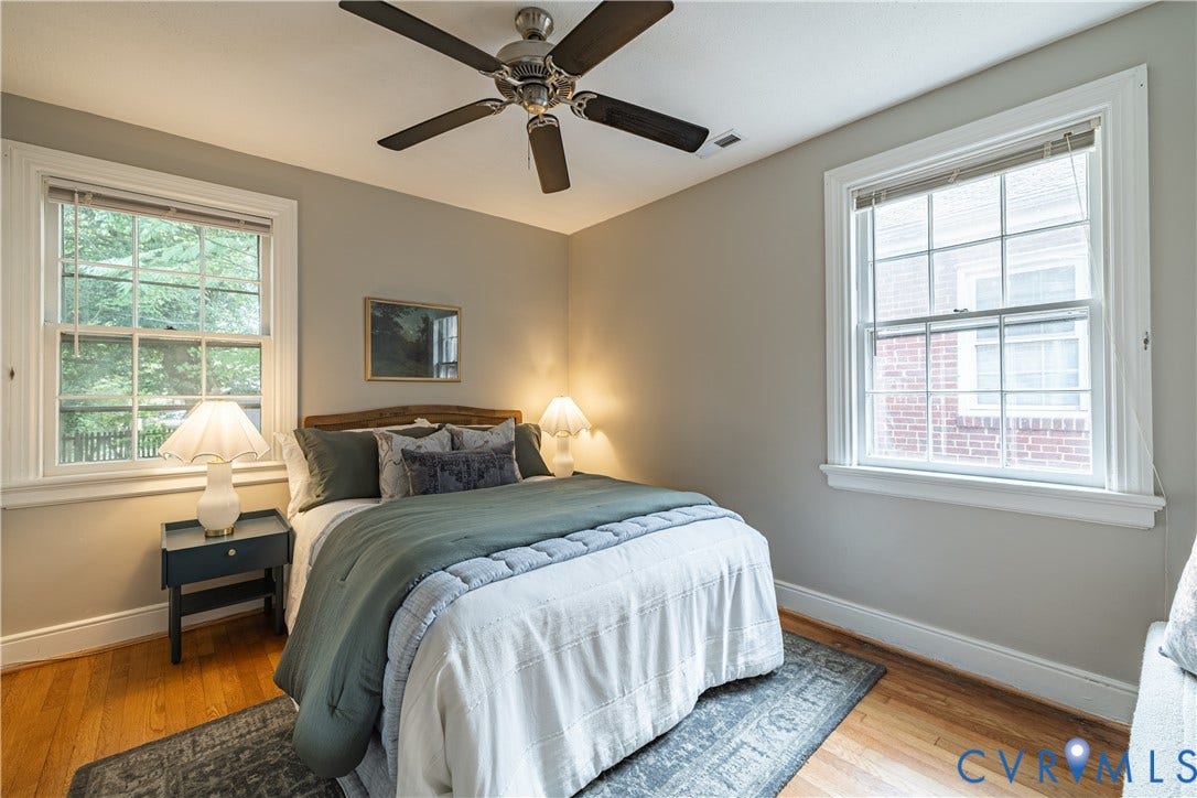 3903 Floyd Avenue, Richmond, VA 23221 Bedroom featuring Hardwoods, two large windows with white trim, a ceiling fan with dark blades