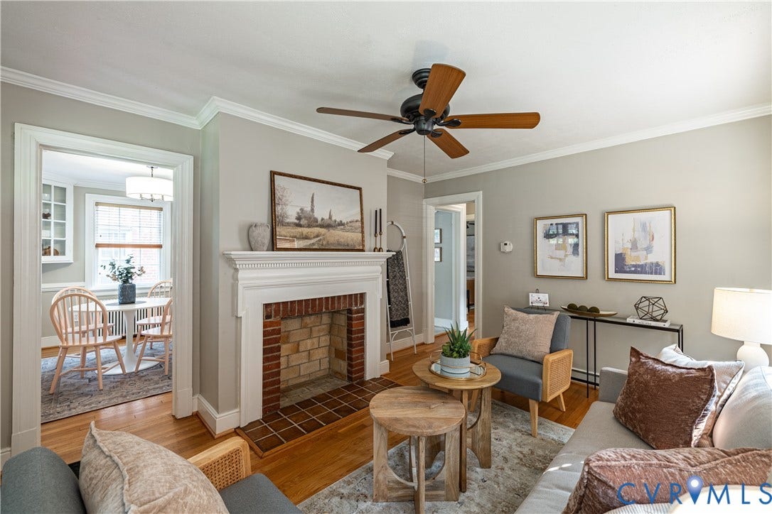 3903 Floyd Avenue, Richmond, VA 23221 Living area featuring a brick fireplace with a white mantel, hardwoods, and a ceiling fan