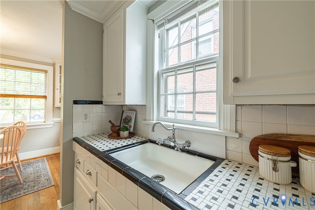 3903 Floyd Avenue, Richmond, VA 23221 Kitchen featuring a white porcelain sink with a wall-mounted faucet, white cabinetry