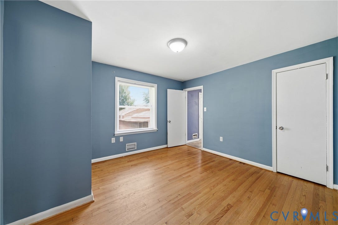 1214 Southbury Avenue, Henrico, VA 23231 Spacious interior room featuring wood-finish flooring, a white trim window, blue painted walls, and white doors