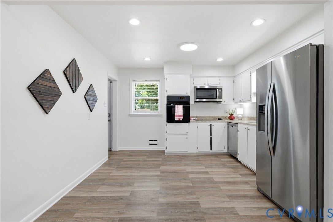 1214 Southbury Avenue, Henrico, VA 23231 Kitchen featuring wood-finish flooring, white cabinetry, a built-in oven, stainless steel microwave, and a stainless steel refrigerator