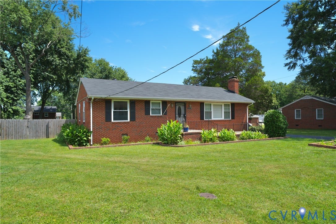 1214 Southbury Avenue, Henrico, VA 23231 Brick exterior ranch-style residence featuring a dark shingle roof, black window shutters, and a front porch with black railings