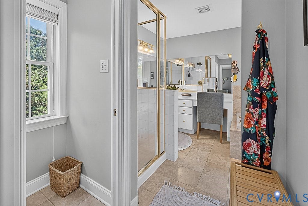 705 Lakewater Drive, Henrico, VA 23229 Bathroom featuring 2 vanities w/dual sinks, extensive mirror & natural Stone tile.