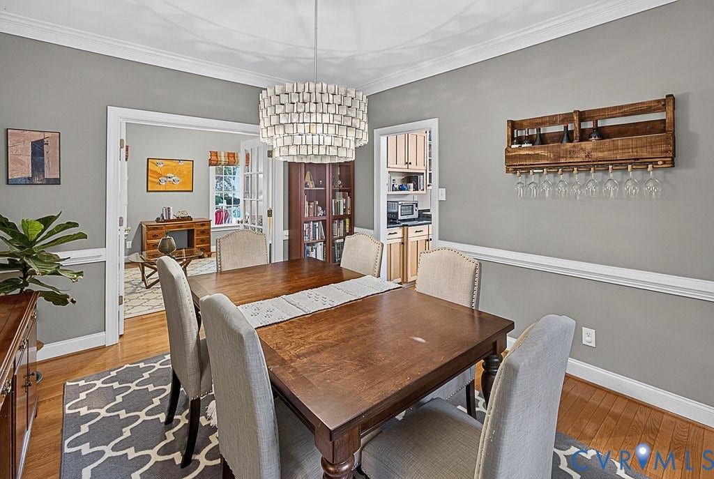 705 Lakewater Drive, Henrico, VA 23229 Dining area featuring wood-finish flooring, crown molding, and a decorative chandelier
