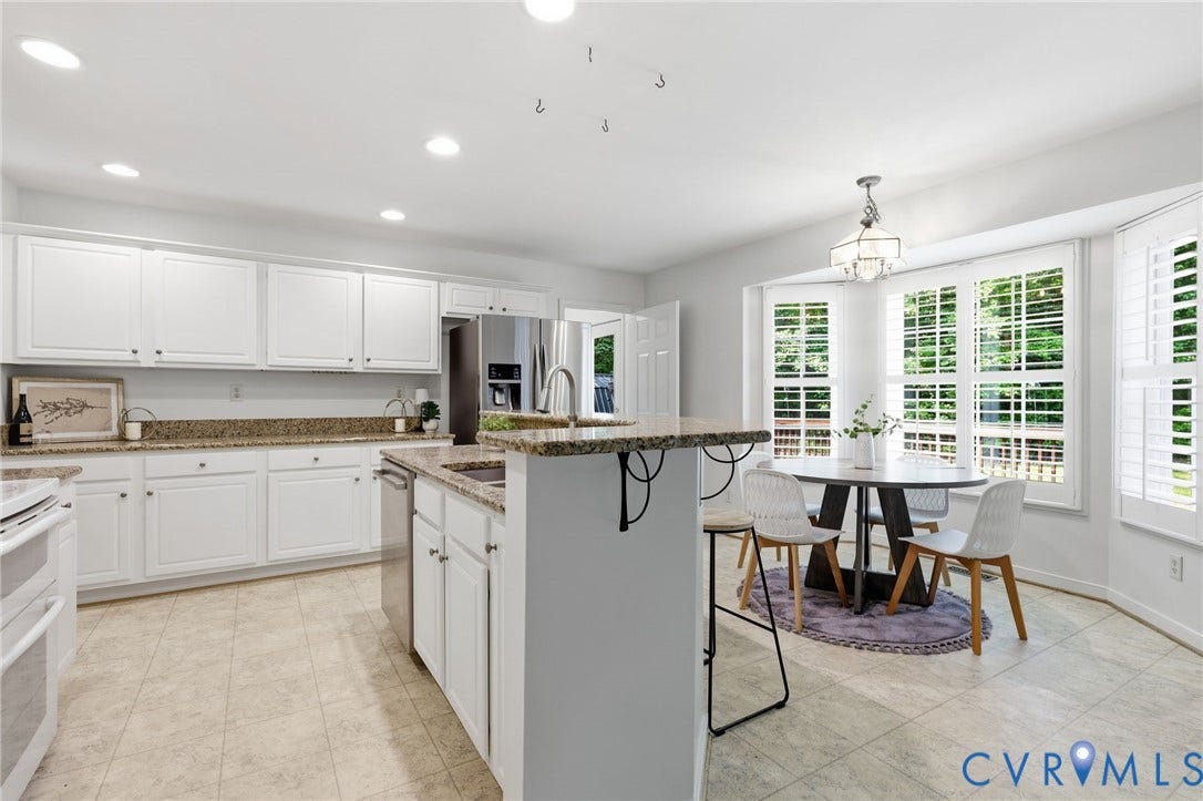 Kitchen featuring white cabinetry, stone countertops, stainless steel appliances, and tile flooring