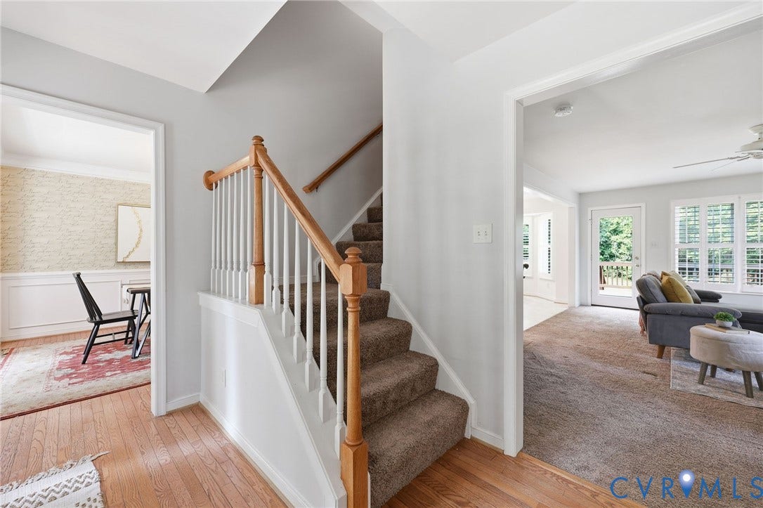 Entryway featuring a wood-finish floor and a staircase with wood handrails