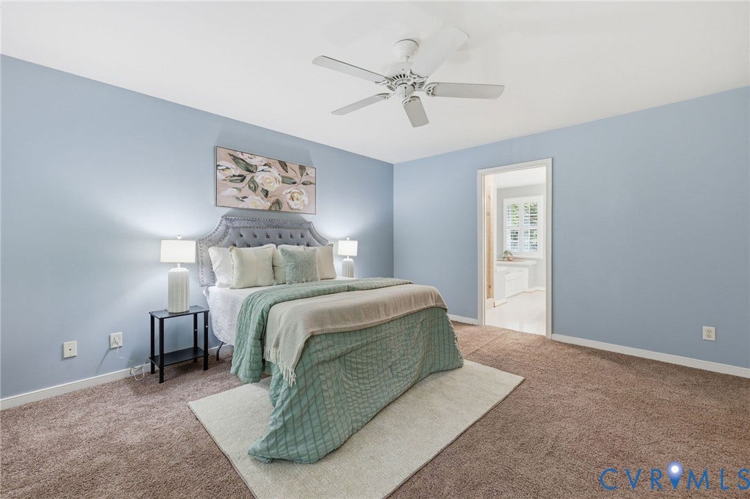 Carpeted bedroom featuring light blue walls and a white ceiling fan