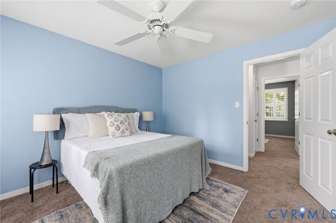 Bedroom featuring light blue walls, brown carpet, and a white ceiling fan with light