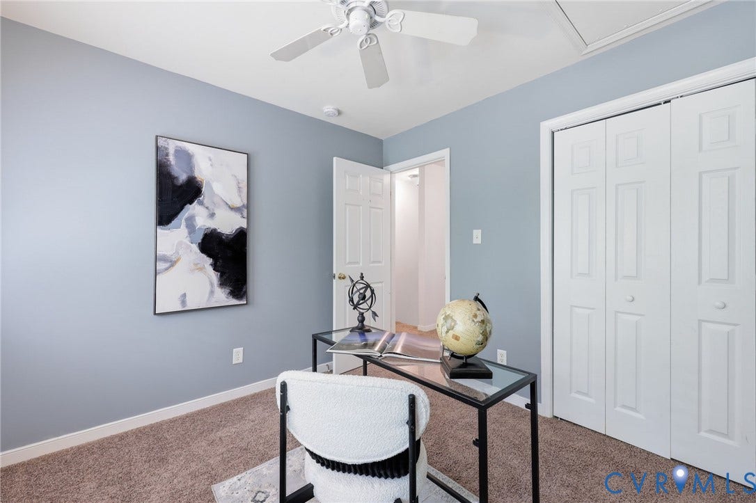 Bedroom featuring light blue walls, brown carpet flooring, and a white ceiling fan