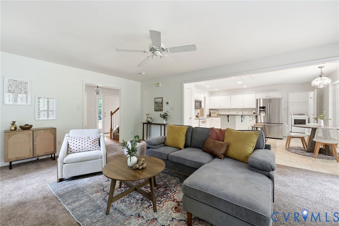 Open-concept living space featuring a spacious carpeted area, overhead ceiling fan, and recessed lighting