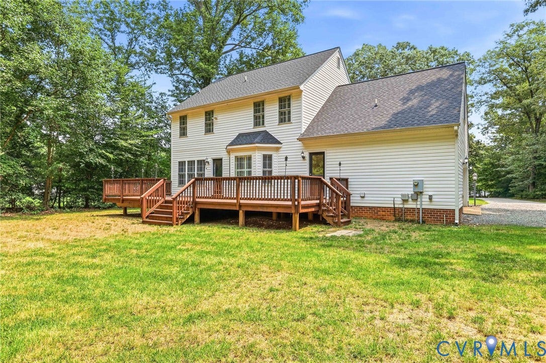 Rear exterior featuring a multi-level wood deck, white siding, and a bay window
