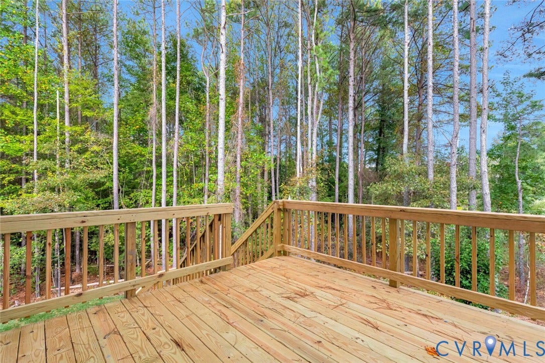 Spacious outdoor deck featuring natural wood flooring and coordinating railings