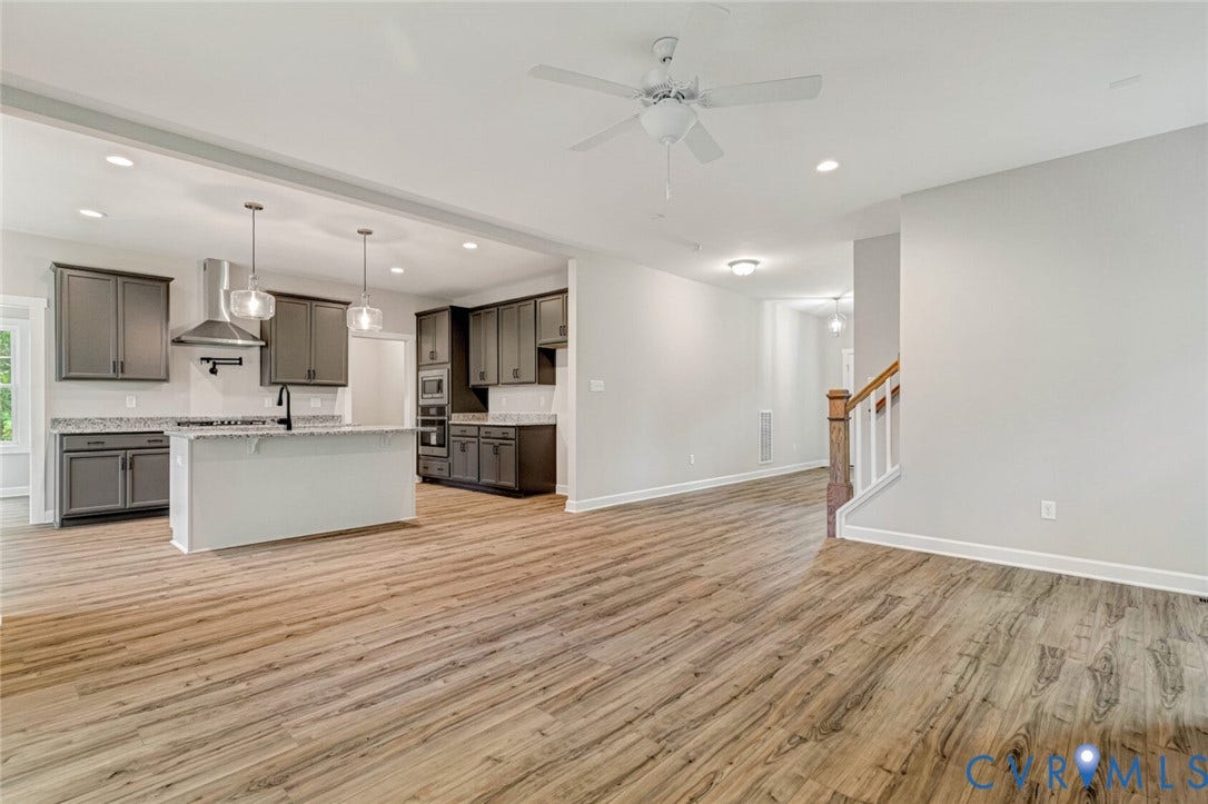 Open-concept living space featuring wood-finish flooring, recessed lighting, and a ceiling fan