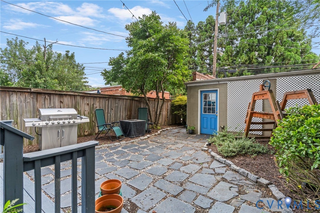 3331 W Grace Street, Monument Avenue, Richmond, VA 23221 Private backyard featuring irregular flagstone paving, a wood privacy fence, and a detached structure with a blue door