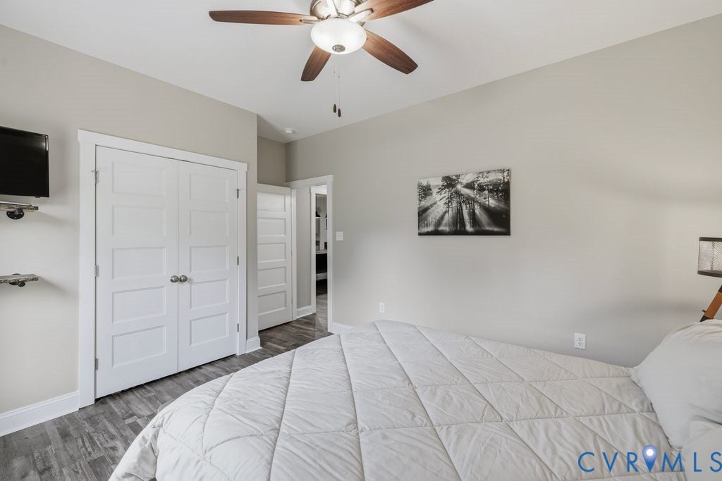 3259 Three Bridge Road, Powhatan, VA 23139 Bedroom featuring wood-finish flooring, a ceiling fan with integrated lighting, and multiple panel doors