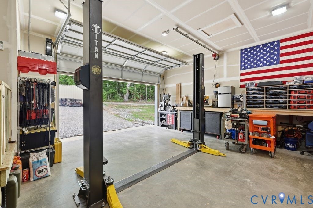 3259 Three Bridge Road, Powhatan, VA 23139 Spacious garage featuring a concrete floor, overhead lighting, and built-in workbench storage