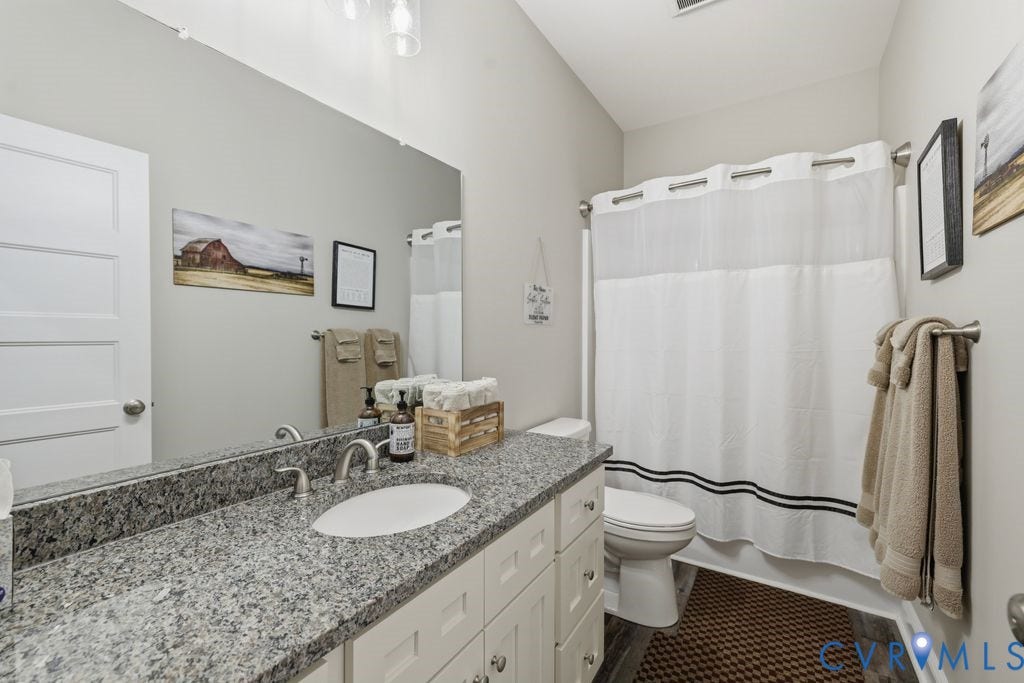 3259 Three Bridge Road, Powhatan, VA 23139 Bathroom featuring a white vanity with brushed nickel hardware, a speckled stone countertop, an integrated sink, and an expansive wall mirror