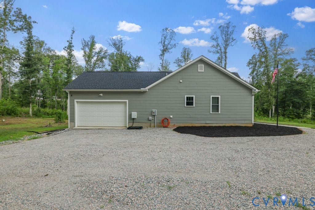 3259 Three Bridge Road, Powhatan, VA 23139 Detached garage with light green siding, a large white garage door, and a dark shingle roof
