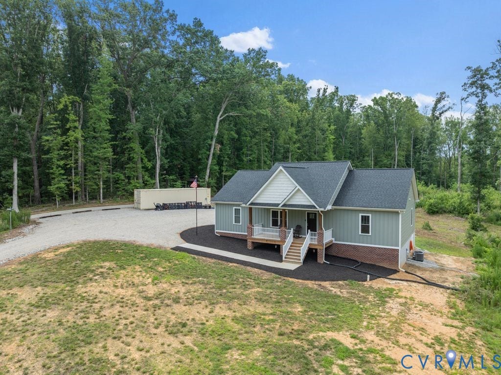 3259 Three Bridge Road, Powhatan, VA 23139 Contemporary craftsman-style residence featuring light green siding, a dark shingled roof, a covered front porch with white railings, and a brick foundation