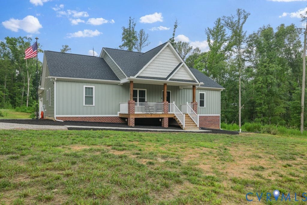 3259 Three Bridge Road, Powhatan, VA 23139 Residential property featuring light green vertical siding, a dark shingle roof, and a red brick foundation