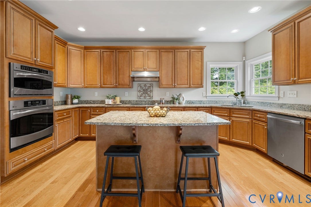 2936 Bayfront Way, Midlothian, VA 23112 Spacious, custom kitchen features wood floors, tons of cabinets and counter space, Granite counters, stainless steel appliances, custom cabinets, recessed lighting, large island with breakfast bar, walk-in pantry and a large eat-in area with deck access.
