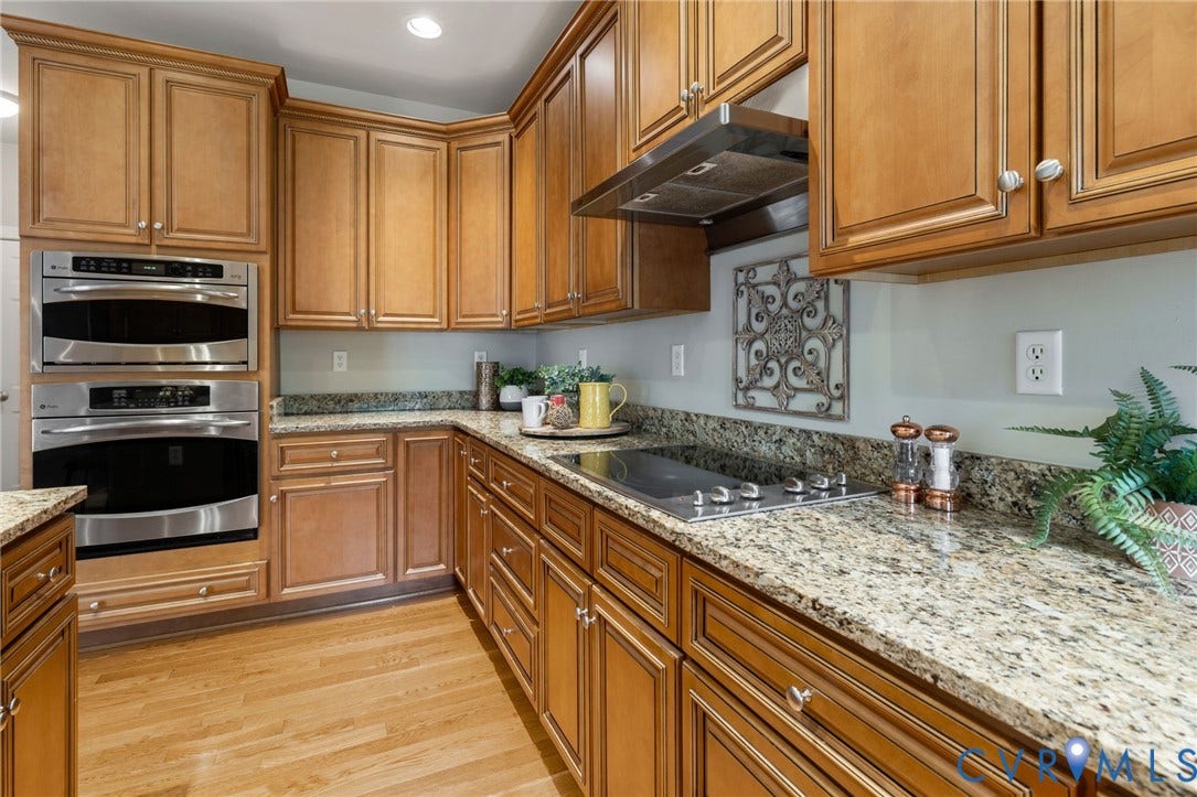 2936 Bayfront Way, Midlothian, VA 23112 Spacious, custom kitchen features wood floors, tons of cabinets and counter space, Granite counters, stainless steel appliances, custom cabinets, recessed lighting, large island with breakfast bar, walk-in pantry and a large eat-in area with deck access.