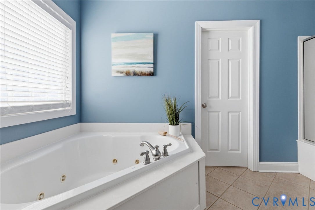 2936 Bayfront Way, Midlothian, VA 23112 First floor primary bathroom with ceramic tile flooring, double vanity, linen closet, water closet, jetted tub and large shower with seat.