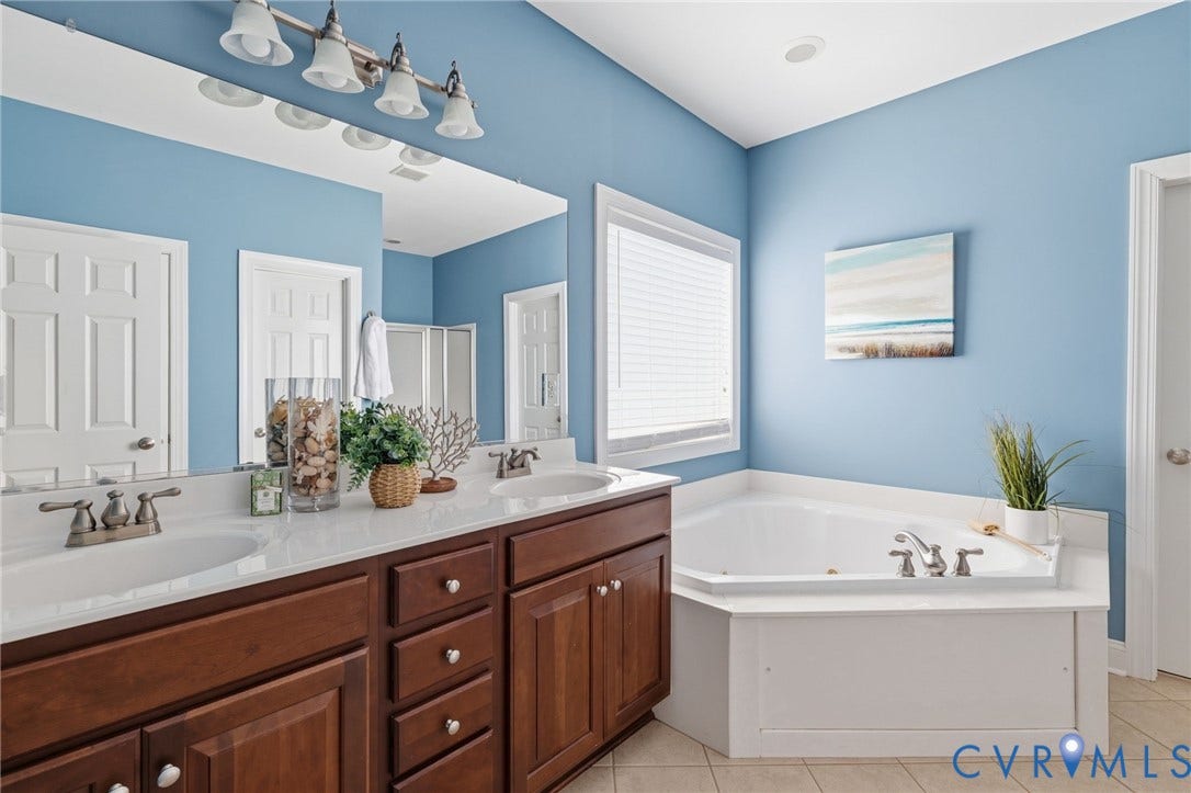 2936 Bayfront Way, Midlothian, VA 23112 First floor primary bathroom with ceramic tile flooring, double vanity, linen closet, water closet, jetted tub and large shower with seat.