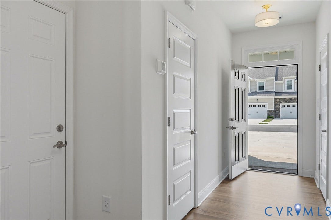 10880 Farmstead Mill Lane, Glen Allen, VA 23059 Entryway featuring wood-finish flooring, white paneled doors, and a decorative semi-flush mount ceiling fixture