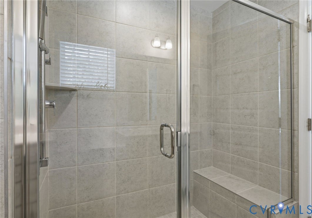 10880 Farmstead Mill Lane, Glen Allen, VA 23059 Glass-enclosed shower featuring large format tile, a built-in bench, and a recessed soap niche