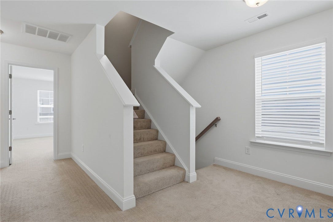 10880 Farmstead Mill Lane, Glen Allen, VA 23059 Carpeted staircase with white balustrade, window with blinds, and neutral wall paint