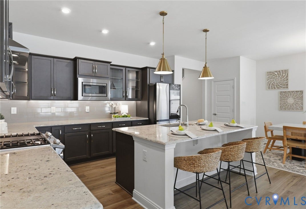 10880 Farmstead Mill Lane, Glen Allen, VA 23059 Modern kitchen featuring dark cabinetry, stainless steel appliances, and light stone-finish countertops
