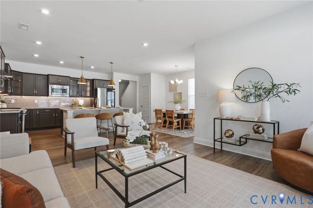 10880 Farmstead Mill Lane, Glen Allen, VA 23059 Open-concept living area featuring wood-finish flooring, recessed lighting, and a kitchen with dark cabinetry, stainless steel appliances, and a light-toned island with pendant lighting