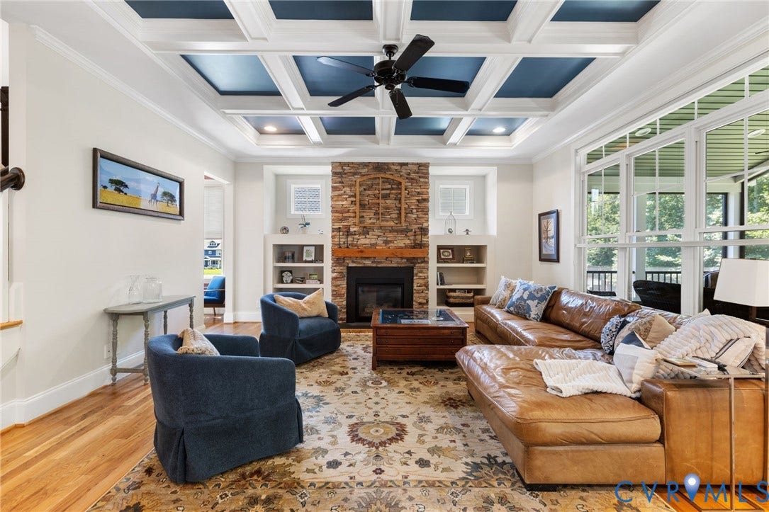 15936 Alsdell Road, Hallsley, Midlothian, VA 23112 Living area featuring a coffered ceiling with blue inserts, a stone-faced fireplace with a wood mantle, built-in shelving, hardwood flooring, and large windows