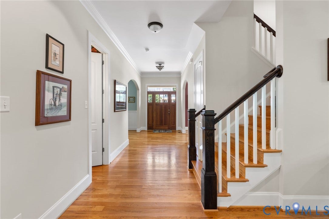 15936 Alsdell Road, Hallsley, Midlothian, VA 23112 Spacious hallway featuring rich wood-finish flooring, a traditional wooden staircase with white risers and dark wood handrail, an arched doorway, a solid wood entry door with glass panels, and crown molding