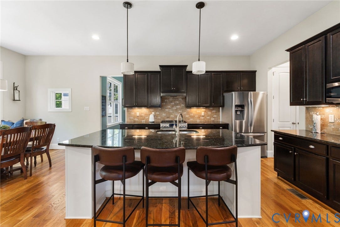 15936 Alsdell Road, Hallsley, Midlothian, VA 23112 Kitchen featuring a large island with seating, dark wood cabinetry, stainless steel appliances, and a mosaic tile backsplash