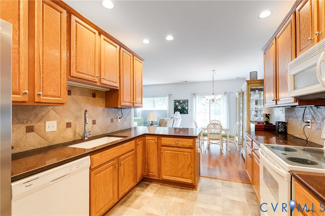 130 Carriage Point Lane, Henrico, VA 23059 Kitchen Featuring New Luxury Vinyl Flooring, Light Wood Cabinetry, and Granite Countertops.