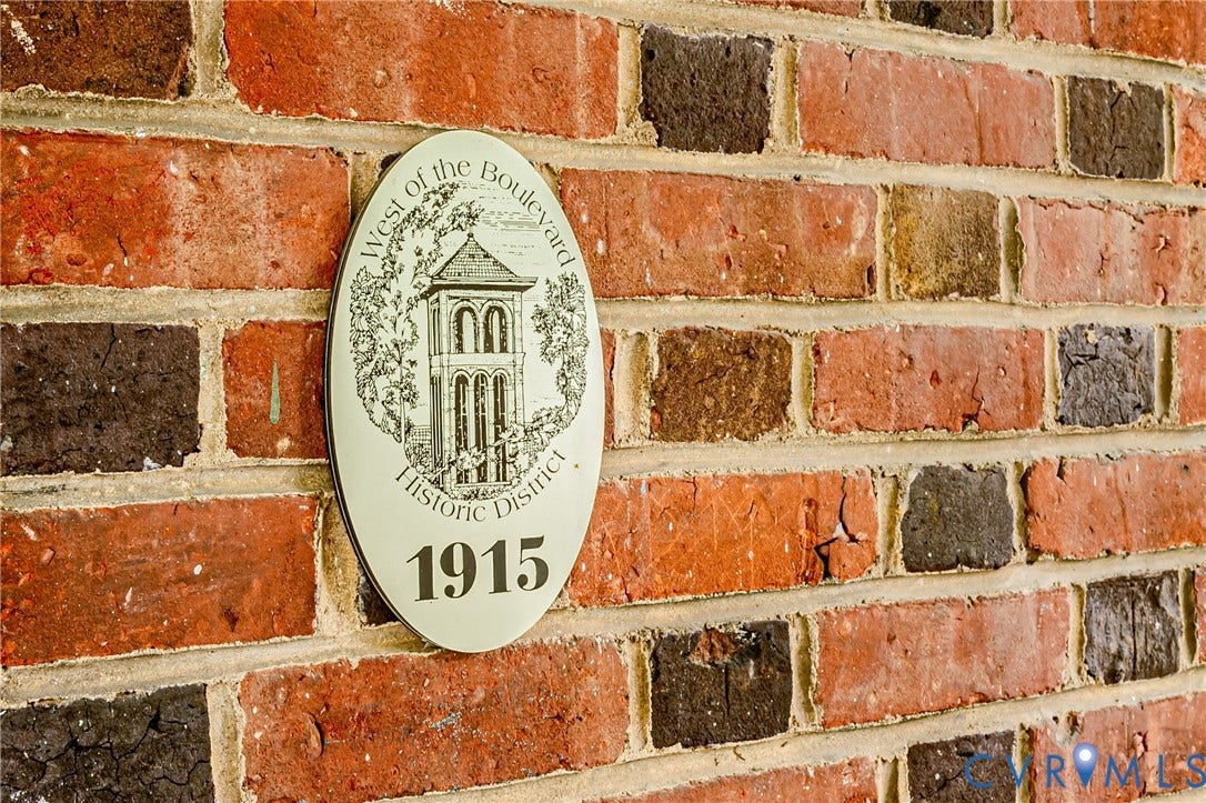 Mixed-tone brick exterior featuring a "West of the Boulevard Historic District 1915" plaque