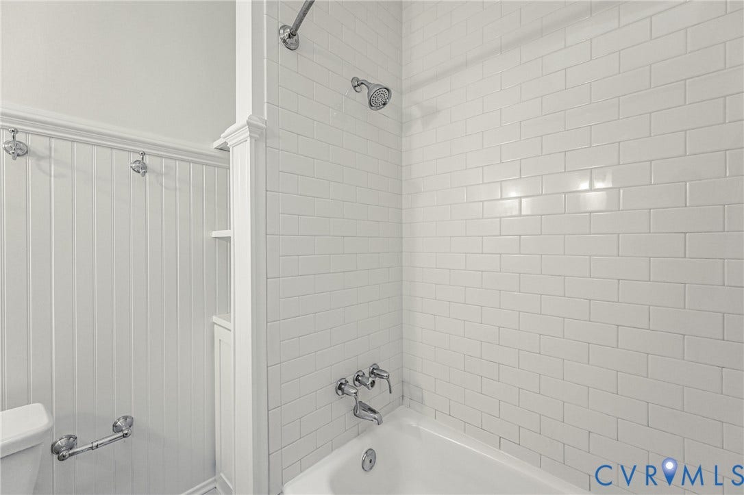 Tub and shower combination featuring white subway tile surround and chrome fixtures