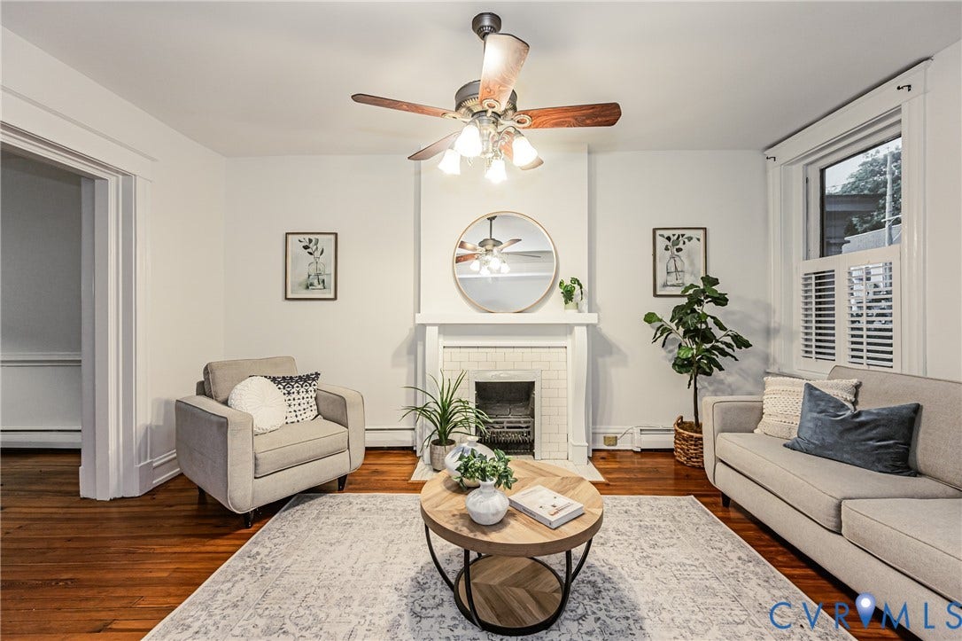 Hardwood flooring throughout featuring a fireplace with a tiled surround and mantel