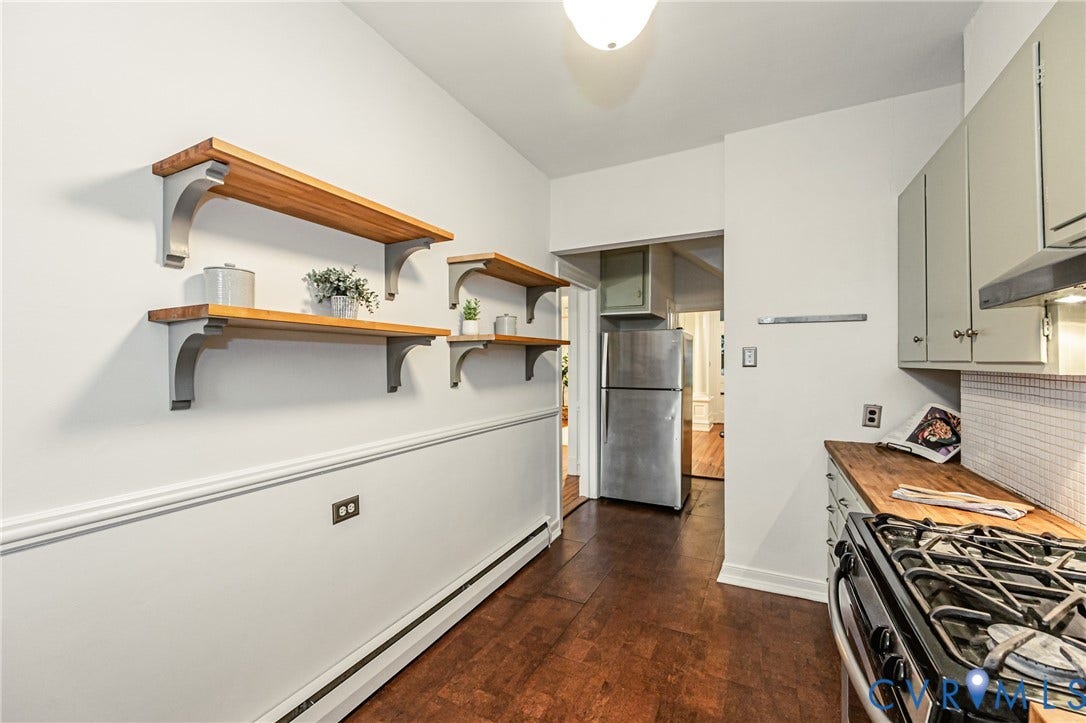 Kitchen featuring wood-finish flooring and light-toned walls with wainscoting