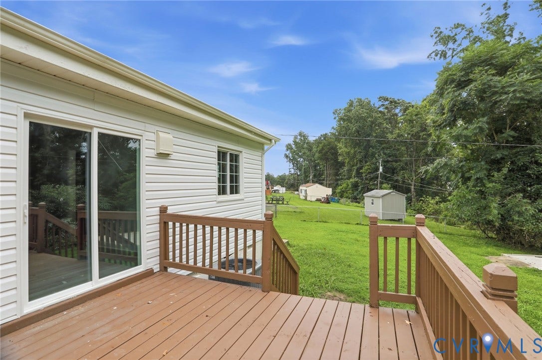 5301 Dalglish Road, Henrico, VA 23223 Spacious wood-finish deck with railing and stairs overlooking a large grassy yard