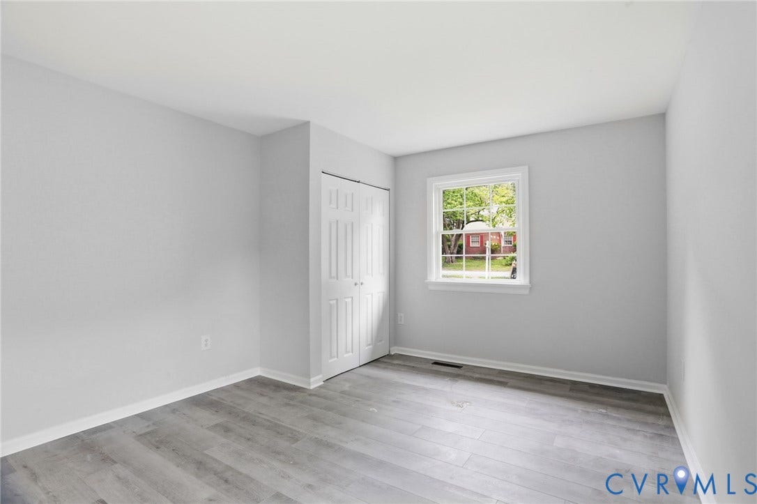 5301 Dalglish Road, Henrico, VA 23223 Room featuring wood-finish flooring, white baseboards, a single window, and bi-fold closet doors