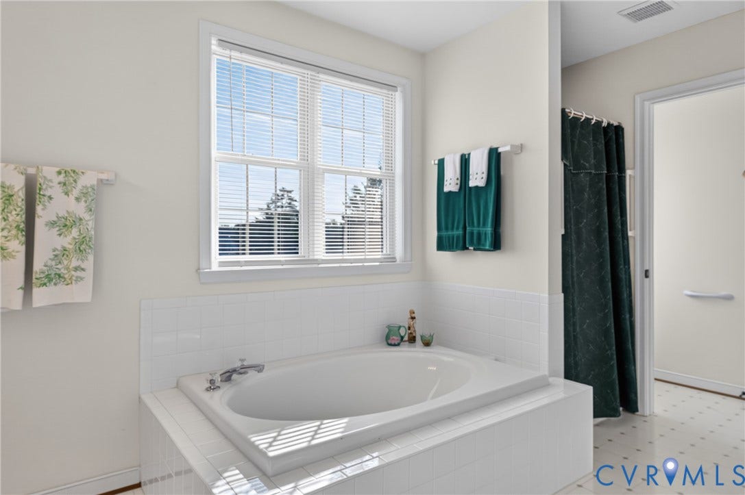 10817 Correnty Drive, Glen Allen, VA 23059 Soaking tub with white tile surround, double window with blinds, and white wall finishes