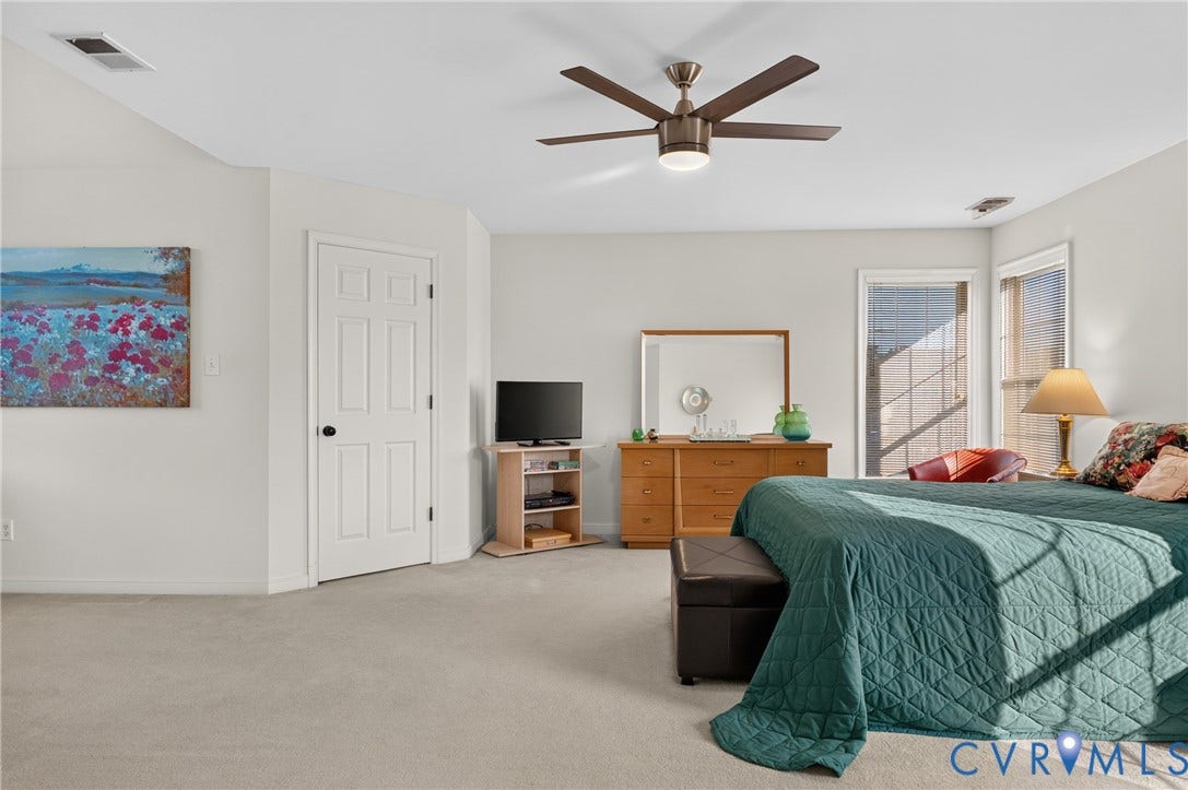 10817 Correnty Drive, Glen Allen, VA 23059 Carpeted interior space featuring a five-panel interior door with a black doorknob, a modern ceiling fan with integrated lighting, and multiple windows