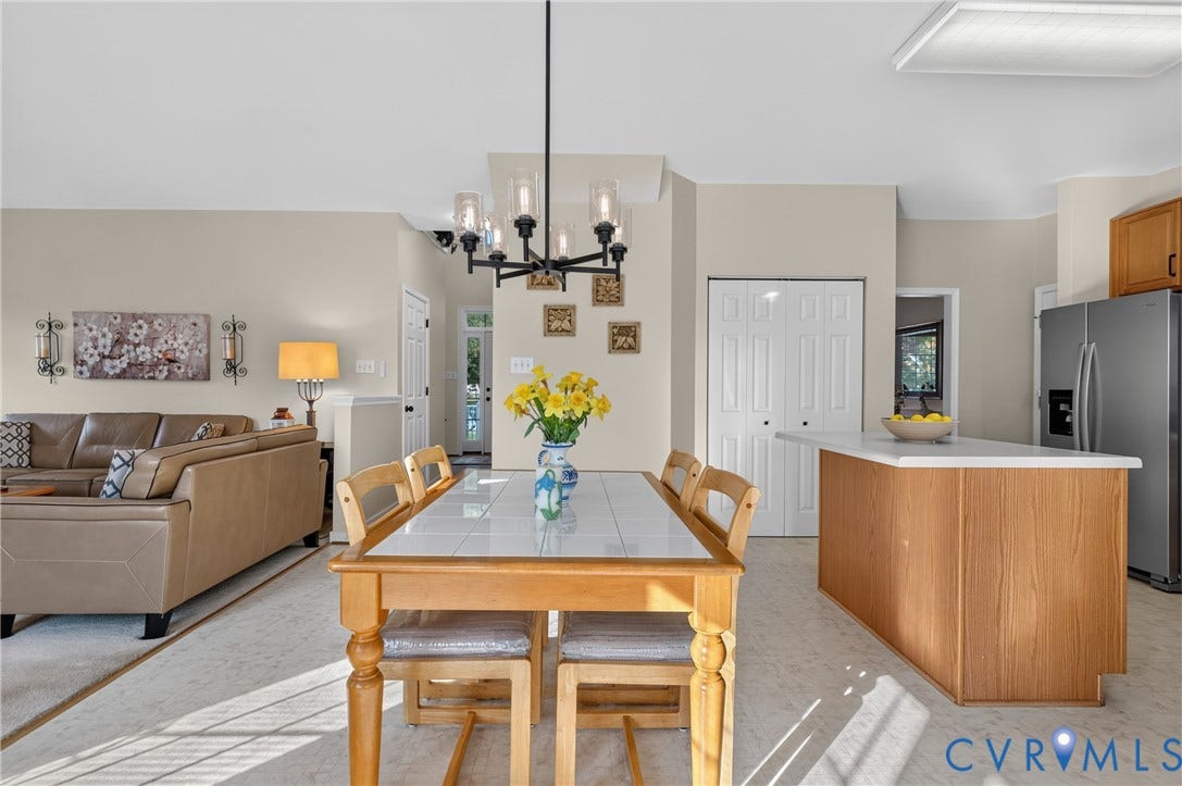 10817 Correnty Drive, Glen Allen, VA 23059 Open-concept living area featuring a dining table with a tiled surface, a contemporary chandelier, and light-toned flooring